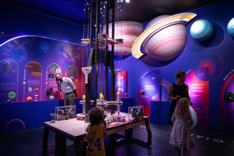 Family exploring the space exhibit Our Cosmic Coast at the Museum
