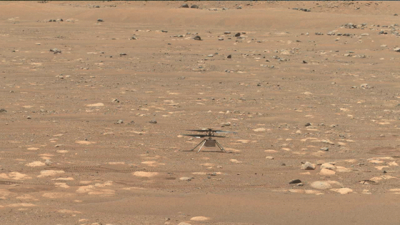 The little Ingenuity helicopter on the sandy and rocky Martian surface