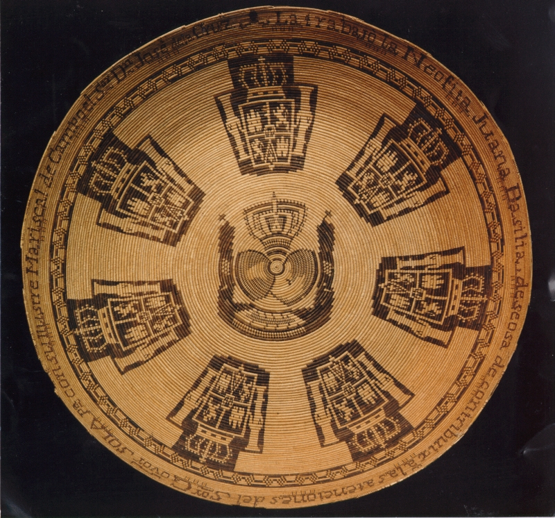 A very large and detailed basket, with heraldic designs including crowns, and text running around the edge describing who made the basket and for whom